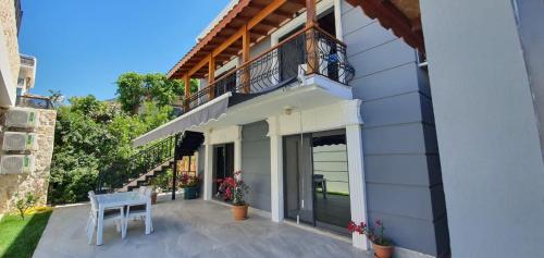 a patio of a house with a table and a balcony at Nur Suites & Hotels in Kalkan