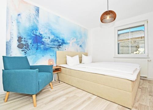 1 dormitorio con 1 cama y 1 silla azul en Katschow Hus Achterland en Katschow