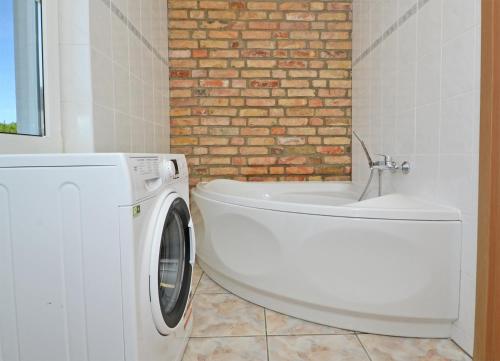baño con lavadora blanca y pared de ladrillo en Katschow Hus Achterland en Katschow