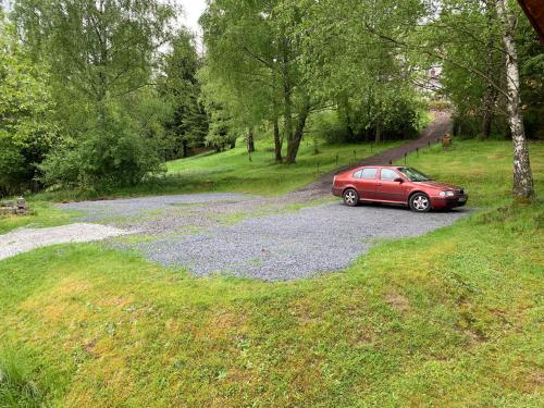 a red car parked on a gravel road at Mezná 85 in Hřensko