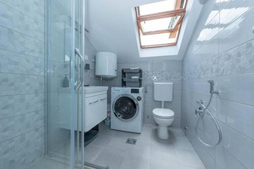 Apartment Vento di Bocche في كوتور: حمام مع غسالة ومرحاض
