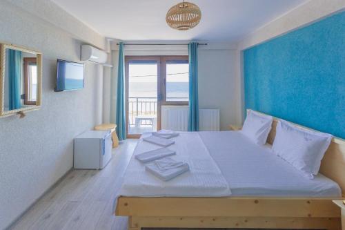 a bedroom with a large bed with a blue wall at Black Sea View Costinesti in Costinesti