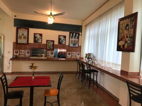 a bar in a restaurant with a table and chairs at Hotel Sociedad y Maristas in Tecolutla