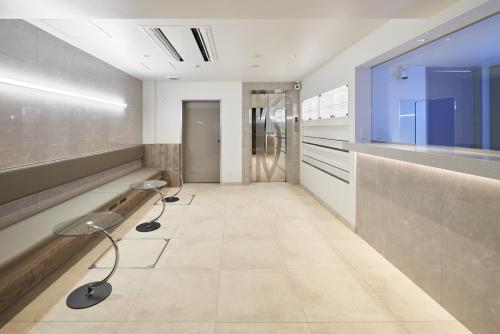 a hallway with two chairs in a room at Shinjuku City Hotel N.U.T.S Tokyo in Tokyo