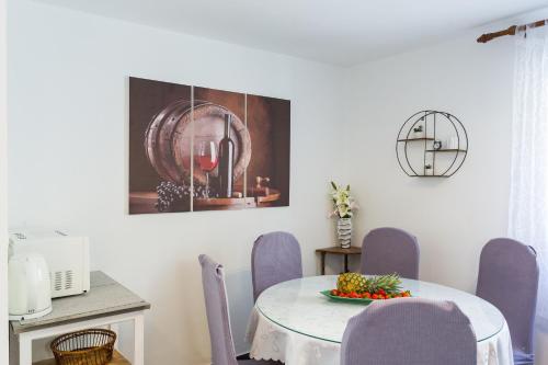 a dining room with a table and purple chairs at Apartments Lidija - sea view apartment with exclusive right of using hot tub or split level apartment with exclusive right of using pool in Podstrana