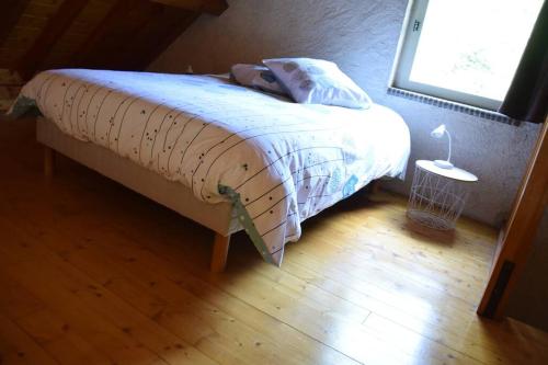 Schlafzimmer mit einem großen Bett und einem Fenster in der Unterkunft Domaine des Montots in Tanlay