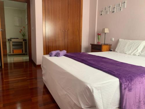 Un dormitorio con una cama grande con una manta morada. en Apartamento Classic OscVict en El Palmar, Murcia. en Murcia