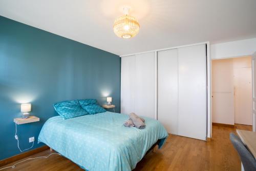 a blue bedroom with a bed and a blue wall at Le Duplex - Disneyland - Rooftop - Wifi in Montévrain