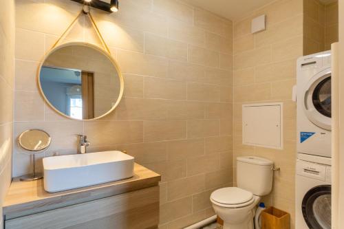 a bathroom with a sink and a washing machine at Le Duplex - Disneyland - Rooftop - Wifi in Montévrain
