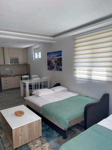 a bedroom with two beds and a table and a kitchen at Studio apartman Holiday in Tivat