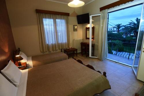 a bedroom with a bed and a living room with a balcony at Argo Hotel in Perama