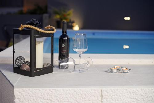 a bottle of wine and a glass on a table at Apartments Lidija - sea view apartment with exclusive right of using hot tub or split level apartment with exclusive right of using pool in Podstrana