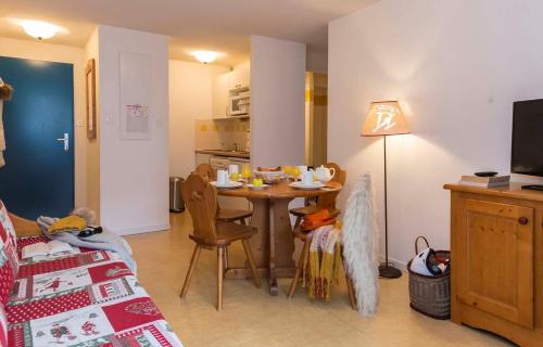 ein Wohnzimmer mit Tisch und Küche in der Unterkunft APPARTEMENT CALME 5 PERSONNEs CENTRE ST LARY PISCINE COUVERTE in Saint-Lary-Soulan