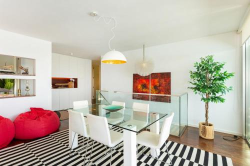 a dining room with a glass table and white chairs at Villa Mar Garajau in Caniço