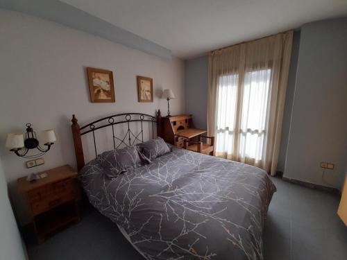 um quarto com uma cama grande e uma janela em Hostal Casa Juan em Castejón de Sos