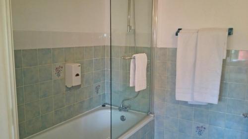 La salle de bains est pourvue d'une douche, d'une baignoire et de serviettes. dans l'établissement Les Closeaux Phil, à Mortain