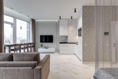 a living room with a couch and a kitchen at Luxurious Apartment with panoramic view in the historic center in Kyiv