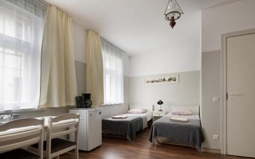 a room with two beds and a sink in it at Promenaadi Villa in Pärnu