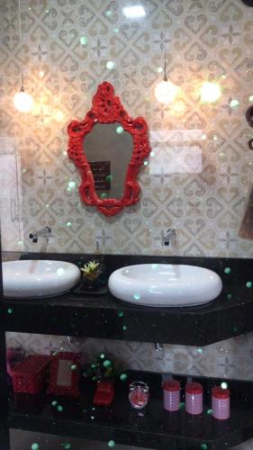 a bathroom with two sinks and a mirror at Casa Belmond in Capitólio
