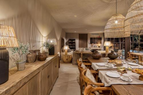 a dining room with tables and chairs and a kitchen at Terra Rosa Country House & Vineyards in Ponte de Lima