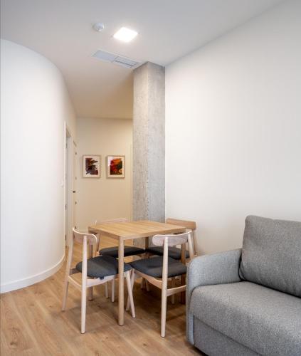 a living room with a table and a couch at Apartamentos Líbere Bilbao La Vieja in Bilbao