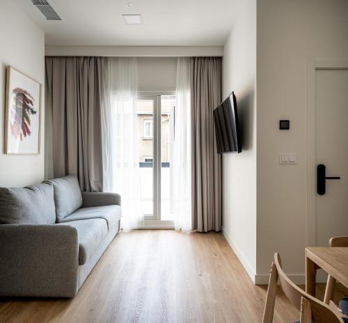 salon z kanapą i oknem w obiekcie Apartamentos Líbere Bilbao La Vieja w mieście Bilbao