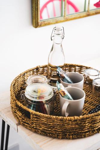 a basket on a table with dishes and a bottle at The Old Store Guest House in Chichester