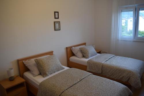 um quarto com 2 camas e uma janela em Dodo em Kaštela