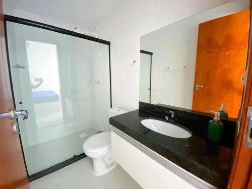 een badkamer met een wastafel, een toilet en een spiegel bij Cobertura Vista Espetacular Com 3 Quartos 403 in Cabo Frio
