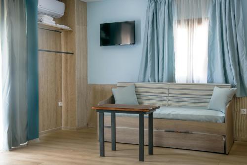 a room with a bench with a table and a window at 3D iliadis Suites in Ierissos