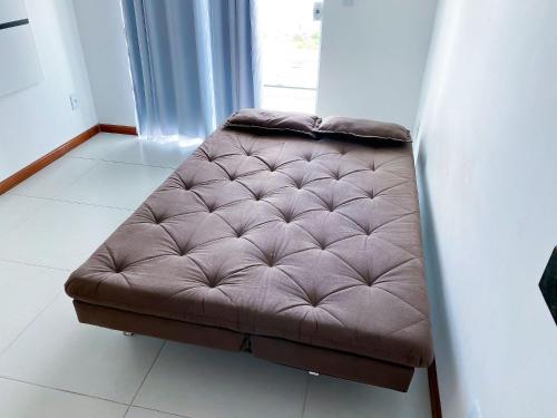 un divano marrone seduto nell'angolo di una stanza di Férias em Família, Aconchego e Privacidade 209 a Cabo Frio
