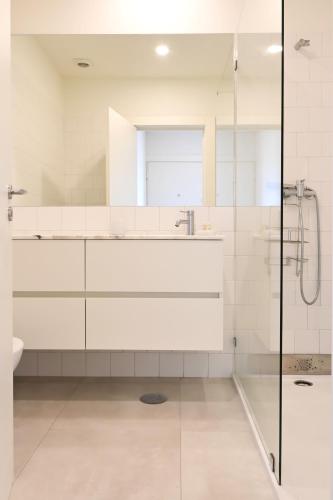 a white bathroom with a sink and a shower at Oporto Chic&Cozy - Batalha II in Porto