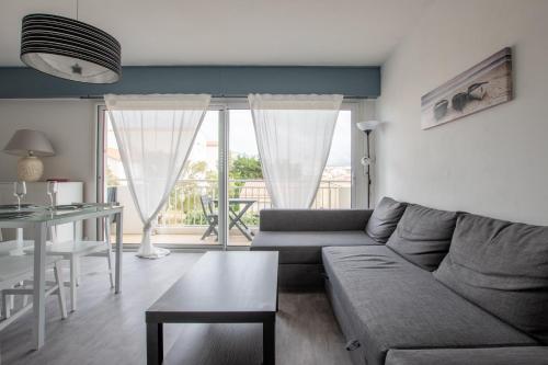 un salon avec un canapé et une table dans l'établissement 50m de la plage - Appart pour 4 - Balcon, à Notre-Dame-de-Monts