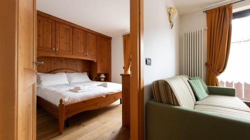Italianway - Coltura 6 في بورميو: غرفة نوم بسرير واريكة في غرفة