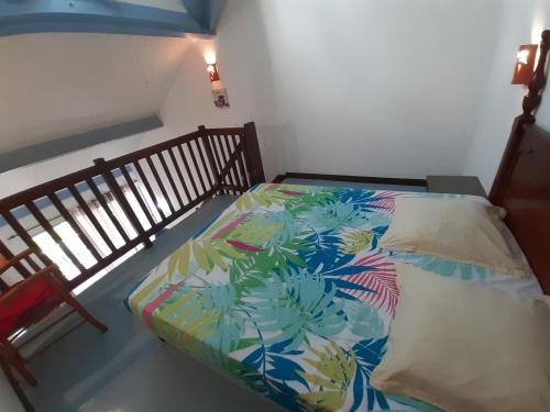 - un lit avec une couette colorée dans l'établissement Appartement Paradis, à Sainte-Anne