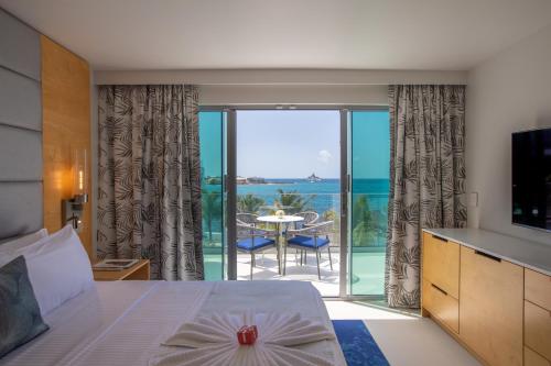 a bedroom with a bed and a view of the ocean at The Morgan Resort Spa & Village in Simpson Bay