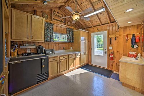 a kitchen with wooden cabinets and a ceiling fan at BBQ Ready Lakeside Milford Home with Paddleboat in Milford