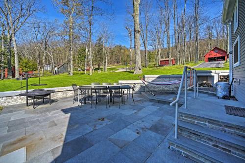 a patio with tables and chairs and a playground at BBQ Ready Lakeside Milford Home with Paddleboat in Milford
