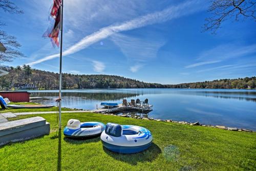two boats sitting on the grass next to a lake at BBQ Ready Lakeside Milford Home with Paddleboat in Milford