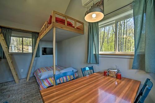 a bedroom with a bunk bed and a table and a bed at Cozy Hillside Retreat with BBQ, Fire Pit, and Trails! in Milford