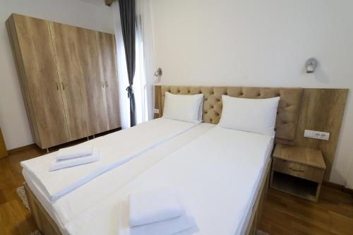 a large white bed with two white towels on it at All Seasons Residence in Zlatibor