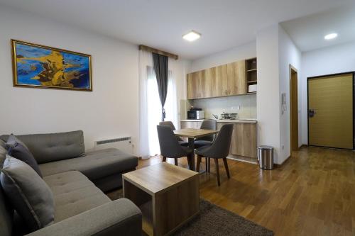 a living room with a couch and a table and a kitchen at All Seasons Residence in Zlatibor