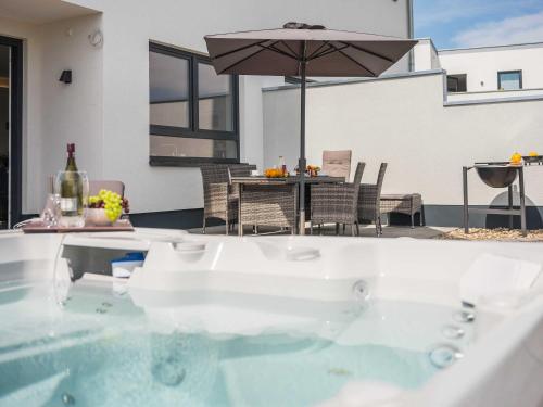 ゲーレン・レビンにあるLuxus Ferienhaus VILLA MEMORYの傘付きのパティオの真ん中にあるバスタブ