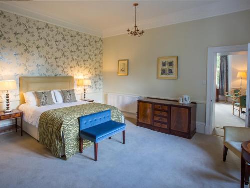 a bedroom with a bed and a table and a chair at Balcary House Hotel in Hawick