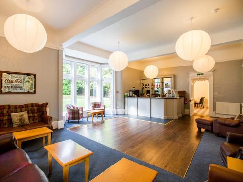a living room with couches and tables and lights at Balcary House Hotel in Hawick
