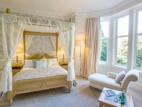 a bedroom with a canopy bed and a couch at Balcary House Hotel in Hawick