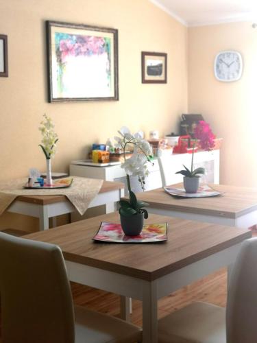 a dining room with two tables with plants on them at Le Orchidee in Bosa