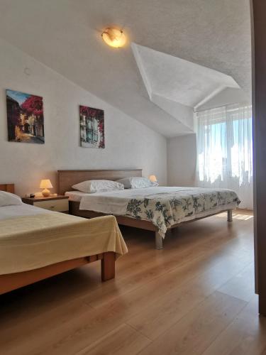 a bedroom with two beds and a window at Apartment Hramina in Murter