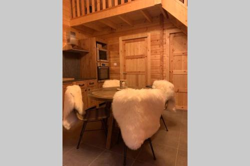 a kitchen with a table and two chairs and a table at Chalet L'Élégance - SPA - Serviettes - Peignoirs - Lits faits - Ménage inclus in Rochesson