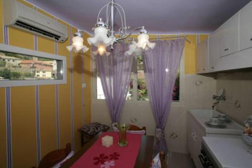 uma cozinha com uma mesa com cortinas roxas e uma janela em The Honeymooners’ Paradise Suite em Vernazza